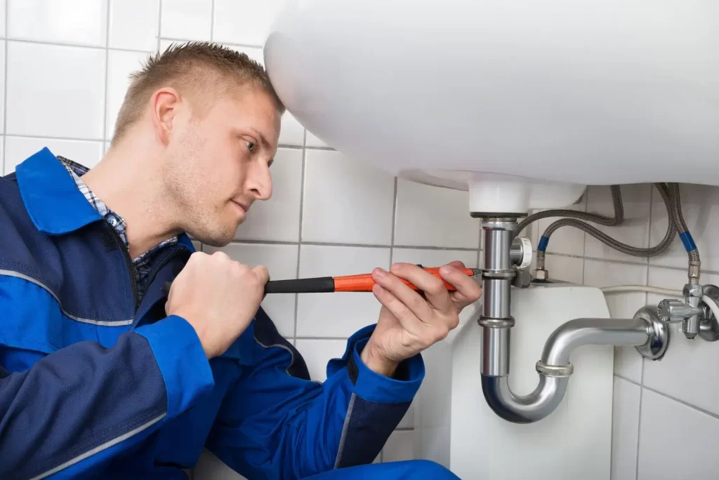 Plumber repairing a sink leak
